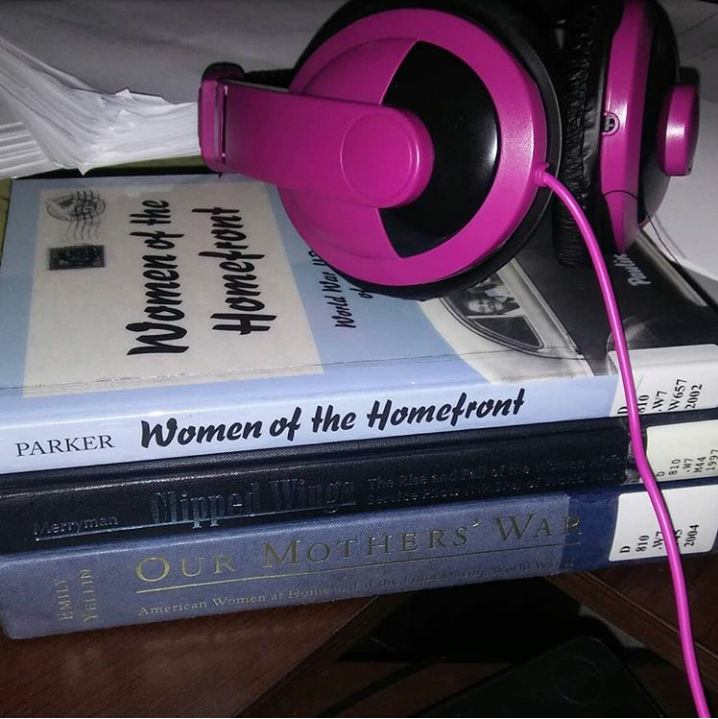 stack of books with noise cancelling headphones